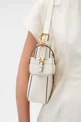 Profile view of model wearing the Oroton Dylan Baguette Bag Charm in CREAM and Premium pebble leather for Women . IP:2