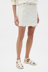 Profile view of model wearing the Oroton Broderie Trim Mini Skirt in SOFT CREAM and 100% heavyweight linen fabric for Women .