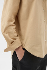 Profile view of model wearing the Oroton Wren Poplin Shirt in CASHEW and 100% cotton fabric for Women .