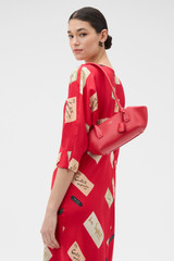 Profile view of model wearing the Oroton Breeze Baguette in Market Red and Premium smooth leather for Women . IP:3