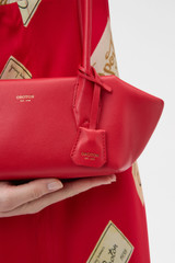 Profile view of model wearing the Oroton Breeze Baguette in Market Red and Premium smooth leather for Women . IP:4