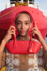Profile view of model wearing the Oroton Breeze Baguette in Market Red and Premium smooth leather for Women . IP:9