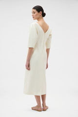 Profile view of model wearing the Oroton Button Detail Dress in Soft Cream and 100% heavyweight linen fabric for Women . IP:5