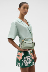 Profile view of model wearing the Oroton Mica Mini Bowler in Gumleaf and Premium pebble leather for Women . IP:2