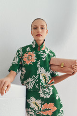 Profile view of model wearing the Oroton Cabana Floral Camp Shirt in Helm Green and 100% silk dupion fabric for Women