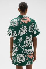 Profile view of model wearing the Oroton Cabana Floral Camp Shirt in Helm Green and 100% silk dupion fabric for Women .