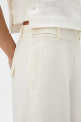 Profile view of model wearing the Oroton Flat Front Pant in Soft Cream and 100% heavy linen fabric for Women . IP:4
