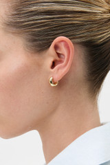 Profile view of model wearing the Oroton Aurie Huggie in Gold and Brass with sterling silver earring post for Women . IP:2