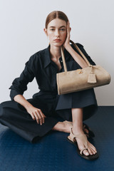 Profile view of model wearing the Oroton Mille Suede Baguette in Caper and Premium suede leather for Women . IP:8
