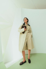 Profile view of model wearing the Oroton Essential Mac in Limestone and 77% cotton and 23% linen blend fabric body with a 100% leather collar for Women . IP:10