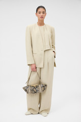 Profile view of model wearing the Oroton Single Breasted Blazer in Almond Creme and 72% Viscose, 28% linen for Women . IP:6