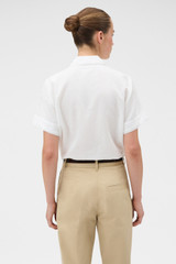 Profile view of model wearing the Oroton Delicate Short Sleeve Shirt in Antique White and 55% linen and 45% cotton blend fabric for Women . IP:5