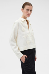 Profile view of model wearing the Oroton Ribbon Trim Shirt in Fresh Cream and 100% midweight linen fabric for Women . IP:3