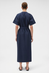 Profile view of model wearing the Oroton Trim Detail Dress in North Sea and 100% cotton fabric for Women . IP:5