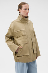 Profile view of model wearing the Oroton Utility Parka in Haystack and 100% cotton fabric for Women .