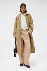 Profile view of model wearing the Oroton Reversible Check Mac in Camel and 100% soft cotton fabric for Women . IP:6
