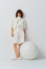 Profile view of model wearing the Oroton Curved Sleeve Jacket in Antique White and 100% cotton fabric for Women . IP:8