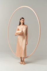 Profile view of model wearing the Oroton Double Satin Sheath Dress in Peach and 100% viscose fabric for Women . IP:8