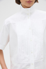 Profile view of model wearing the Oroton Pleat Detail Shirt in White and 100% cotton fabric for Women . IP:4