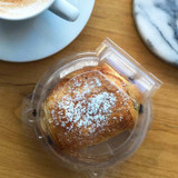 Single 3.75" PLA Dessert Clamshell Container Next To Coffee Mug and Coasters Single 3.75" PLA Dessert Clamshell Container Next To Coffee Mug and Coasters