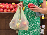 Woman holding apples and BioBag shopping bag
