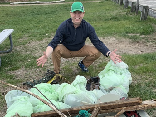 Evan at Good Start Packaging collecting trash from a beach cleanup