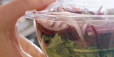 pla salad bowl in a person's hand