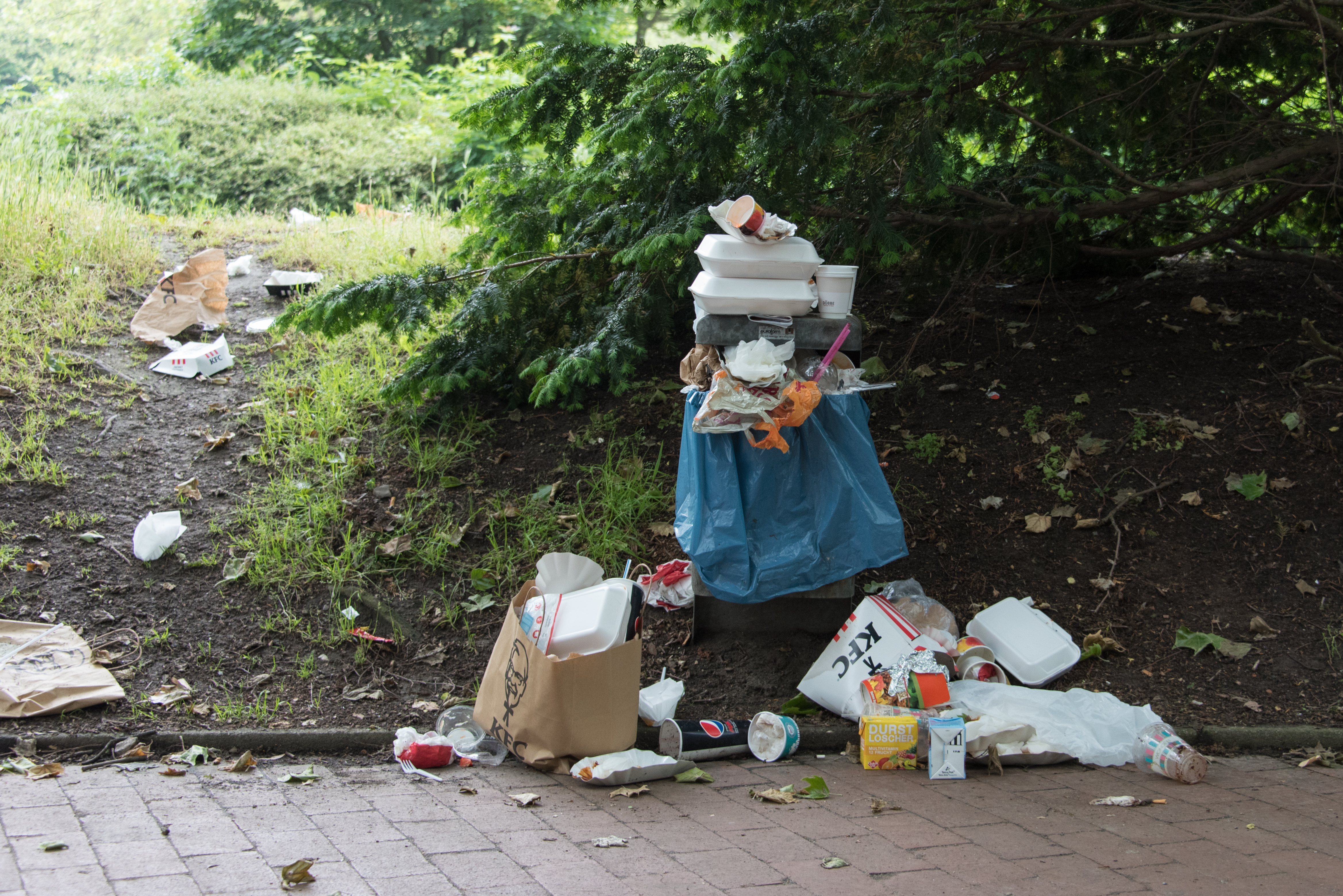 collection of trash outside of trash can