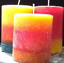 3"x3" Pillar Candles -Round.  three candles each with three layers. One yellow, orange, turquoise. one yellow, red, orange. one red, orange yellow.  All have paper wicks.