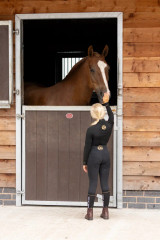 Perfectly produced from quick-dry, sport-tech fabric with excellent four-way stretch and advanced breathability properties, this buttery soft base layer offers a sculpted fit and flattering silhouette. Providing UV block protection (50+) and increased ventilation from a strategically placed airflow system under the arms, across the shoulders, and down the back, it aids body temperature regulation, making it the perfect base layer for the active equestrian. Elegantly finished with exquisite gold detailing. Team with the Supreme riding tights for a timeless look.