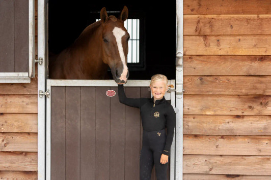 Perfectly produced from quick-dry, sport-tech fabric with excellent four-way stretch and advanced breathability properties, this buttery soft base layer offers a sculpted fit and flattering silhouette. Providing UV block protection (50+) and increased ventilation from a strategically placed airflow system under the arms, across the shoulders, and down the back, it aids body temperature regulation, making it the perfect base layer for the active equestrian. Elegantly finished with exquisite gold detailing. Team with the Supreme riding tights for a timeless look.