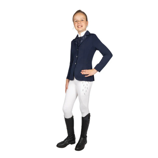 Step into the ring with confidence and style in the Hy Equestrian Roka Reign Show Jacket, a sophisticated blend of tradition and innovation. This beautifully tailored jacket is designed to flatter the rider’s silhouette while offering exceptional comfort and freedom of movement, thanks to its high-performance stretch fabric. Engineered with both form and function in mind, the Roka Reign features a breathable, moisture-wicking lining to keep you cool and composed during competition. The gorgeous diamante detailing adds a touch of sparkle to your competition outfit and classic button fastenings add a refined touch. Lightweight yet durable, this jacket is ideal for all disciplines, offering a polished, professional appearance with every wear.