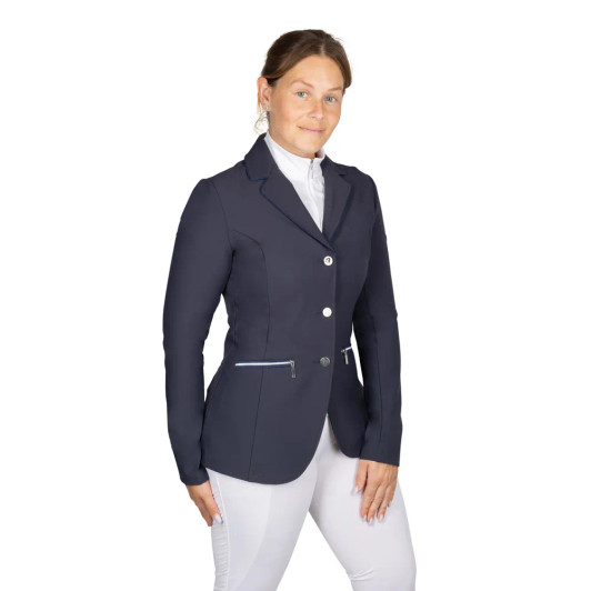 The Hy Equestrian Elevate Artemis Show Jacket is a sophisticated blend of modern tailoring and classic equestrian style. Designed in a smart navy fabric with a flattering, contoured fit, this jacket offers elegance and comfort for competition days. Subtle suede detailing around the collar and around the pockets adds a luxurious touch, giving it a refined finish that stands out in the ring without being overstated. The jacket is fastened with stylish, traditional buttons for a smooth silhouette, along with a back vent to allow freedom of movement in the saddle. Lightweight and breathable, it ensures comfort through long classes while maintaining a polished, professional appearance. Ideal for riders looking to combine timeless style with performance-ready design.