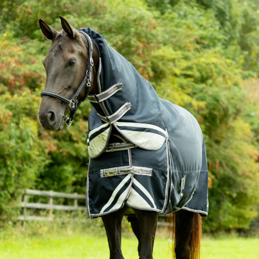The elite DefenceX Shield turnout rug is a high specification rug that has been expertly crafted from a ballistic 1200 denier waterproof and ripstop material to offer ultimate protection. This 200g rug is perfect for when a middleweight layer is needed to protect your horse from the inclement weather. Featuring a snug fit detachable neck with double locking touch tape fastenings for an easy yet secure attachment, that includes an elasticated poll to reduce wind chill and provide a cosy fit. An innovative specially shaped tail flap offers ultimate coverage from rain and wind, detailed with reflective detailing, as well as on the body of the rug and neck to optimise visibility in low light conditions. The mid-rise, generous shoulder gusset allows for a full freedom of movement and padded wither has been expertly designed to guarantee comfort by aiding with alleviating pressure off the wither. The deep cut design is securely fastened with adjustable cross surcingle’s with elasticated inserts and twin buckle clip chest fastenings for stability and to offer the perfect fit. Finished with the choice of wipe clean fillet string and adjustable leg straps, so the rug can be tailored to suit each individual horse.