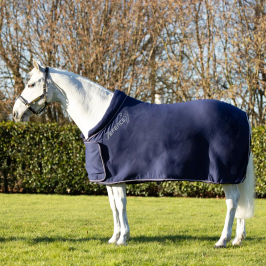 The DefenceX Shield Royal Elite Fleece Rug is a luxurious addition to any horses’ wardrobe. Ideal for use whilst travelling, after bathing or exercise, as a light stable rug or show rug, or under another rug for added warmth. Made from soft fleece fabric which traps the air to help insulate your horse keeping them warm and comfortable. The fabric also wicks moisture away from the skin making it ideal to be put on a damp horse to prevent them from catching a chill. Featuring a rolled cushioned neckline which prevents rubbing at the withers, single fastening front with secure touch tape closure, adjustable cross surcingle’s and wipe clean fillet string. Complete with contrast stitching edging for that extra eye-catching touch for a smart finish.