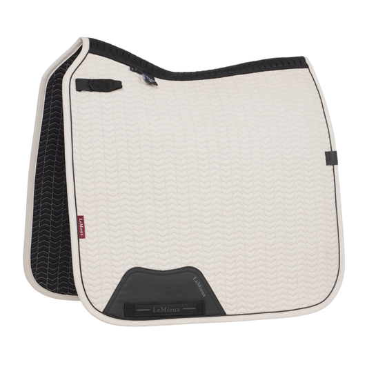 Designed for elite riders with technical performance that everyone can enjoy, the soft shell fabric of the Essence Collection of saddle pads exudes class.

The contour quilted soft shell upper, meticulously designed to hug your horse's curves without wrinkling, is teamed with a soft, breathable self-cool lining. The cooling material is woven with cooling fibres, controlling heat by transferring heat away from the skin and wicking sweat efficiently to cool your horse. The warmer your horse gets, the harder the moisture-activated cooling lining works under the saddle. Combined with a full 3D carbon mesh spine for maximum airflow, this is a saddle pad uniquely designed for hardworking horses.The high wither shape reduces pressure and enhances your saddle's fit. Elasticated saddle straps, thoughtfully designed to be slimmer at the point of connecting to the D-ring, leave room for extra accessories catering to your specific training needs.

The whole pad benefits from extensively researched, soft, friction-free binding that is specially fabricated to contour the edges smoothly. This technique helps retain the perfect saddle pad shape and binding profile. Sporty rubberised piping gives the pad a clean, athletic aesthetic.

The sporty matte-textured faux leather girth protection area is complemented by an embossed logo. Our signature LeMieux hidden girth loop channels mean you can precisely place your girth.

A unique LeMieux branded faux leather tab provides a luxurious finishing touch.