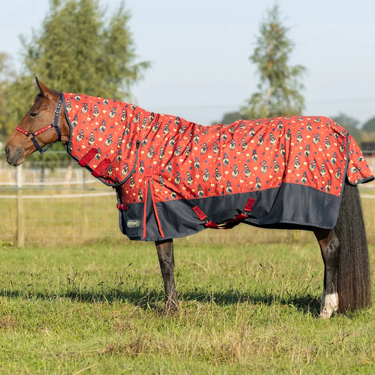 This stunning mediumweight turnout rug from the StormX Original range is the perfect addition to your horse’s wardrobe! Covered in Thelwell cartoons, this attractive red rug has a navy drip strip and subtle coordinating trim and accessories. Featuring a 600 denier waterproof and ripstop outer material, this rug has a 200g fill, perfect for when a heavier layer is required. The integrated contour neck cover means optimum protection and warmth for your horse. Finished with shoulder gusset, adjustable twin buckle chest fastenings, adjustable leg straps and surcingles and tail flap for extra protection, security and comfort.