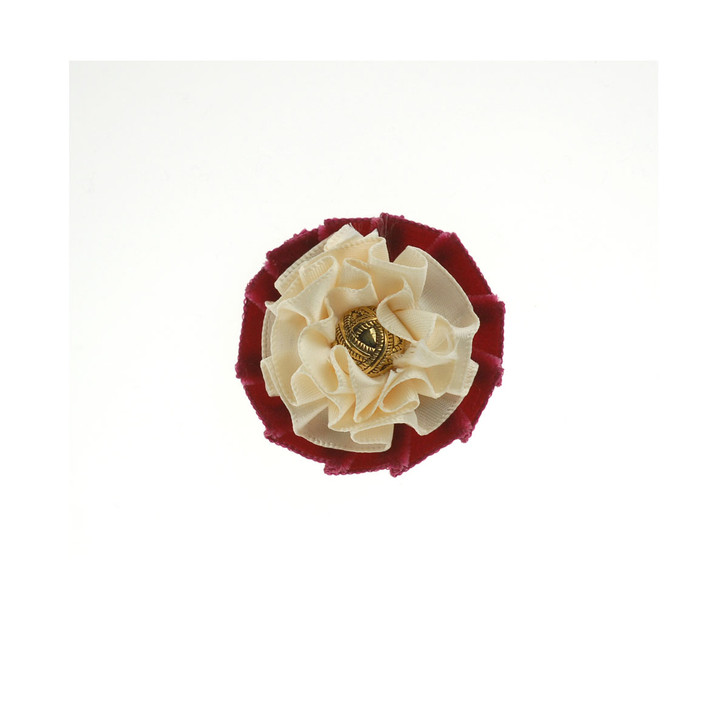 A buttonhole with small pin using velvet and satin ribbon with a stud.