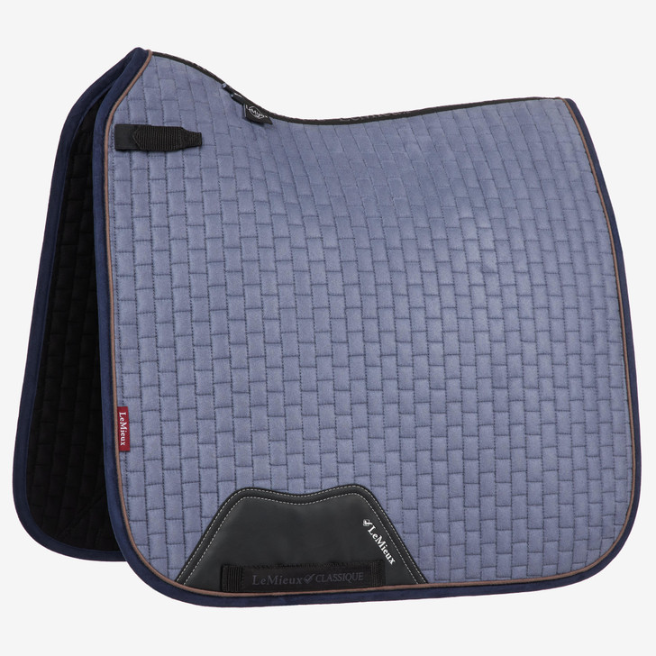 Now with our Super Soft Suede Binding & New PU Leather girth protection area, this beautiful suede Dressage square sets new standards in style & comfort. Now established as the iconic LeMieux look when combined with matching polo bandages and fly hoods there are colours to suit most horses and tastes. Designed to fit a wide range of dressage saddles with its high wither and elasticated D-Ring tabs .
 

The luxurious suede top side with soft suede binding is complimented by a new super soft Bamboo lining to absorb & control sweat under the saddle and are beautifully comfortable and secure - minimising friction.