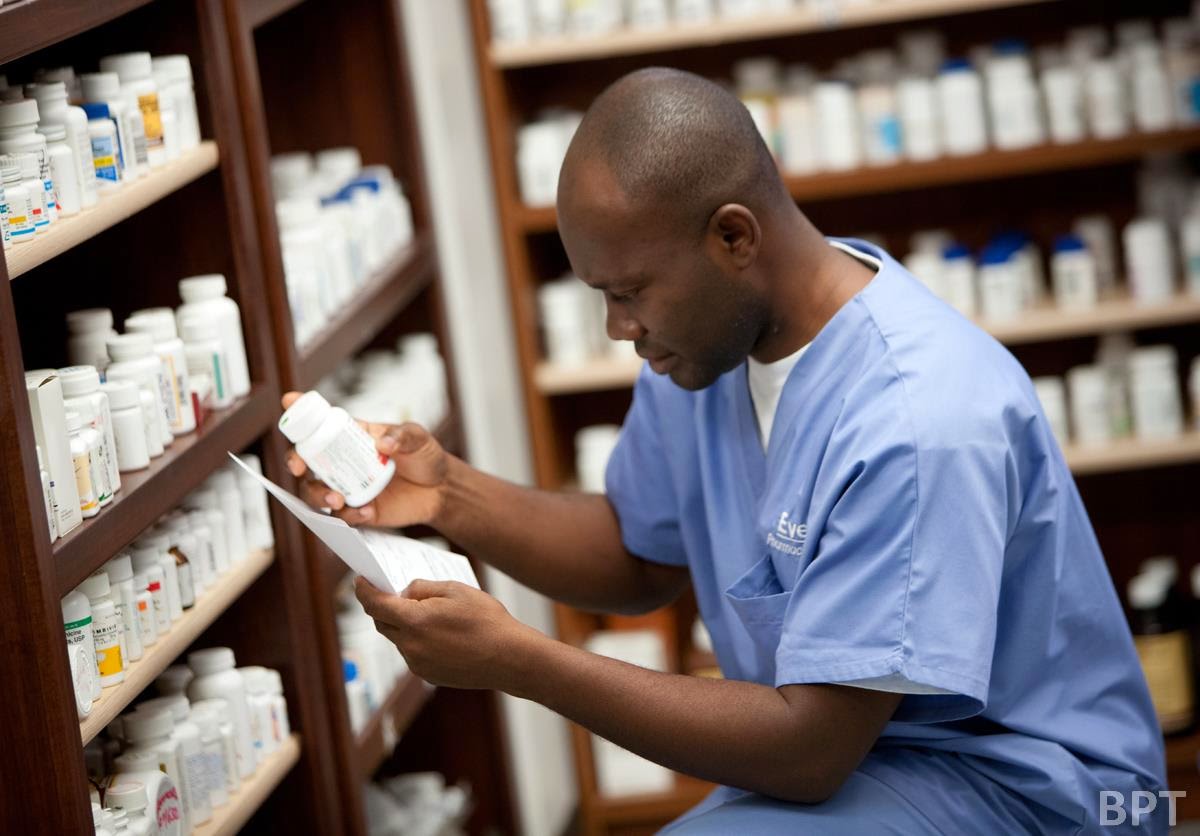 pharmacist checking pill bottle 
