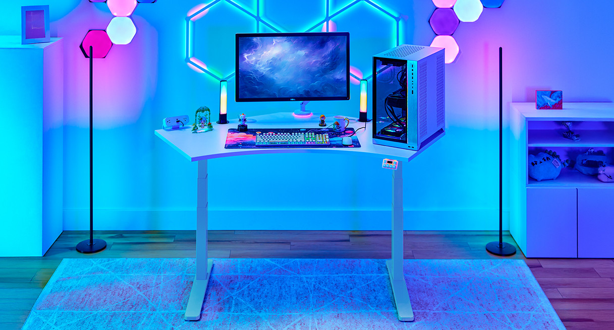 Standing desk setup with monitors and purple-blue lighting