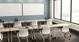 Multiple rows of Flip Top Tables with White Wire Management Modesty Panels and Rollaway Nesting Chairs