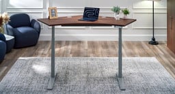 UPLIFT Desk 120-Degree Standing Desk shown with a walnut laminate top on a gray adjustable frame