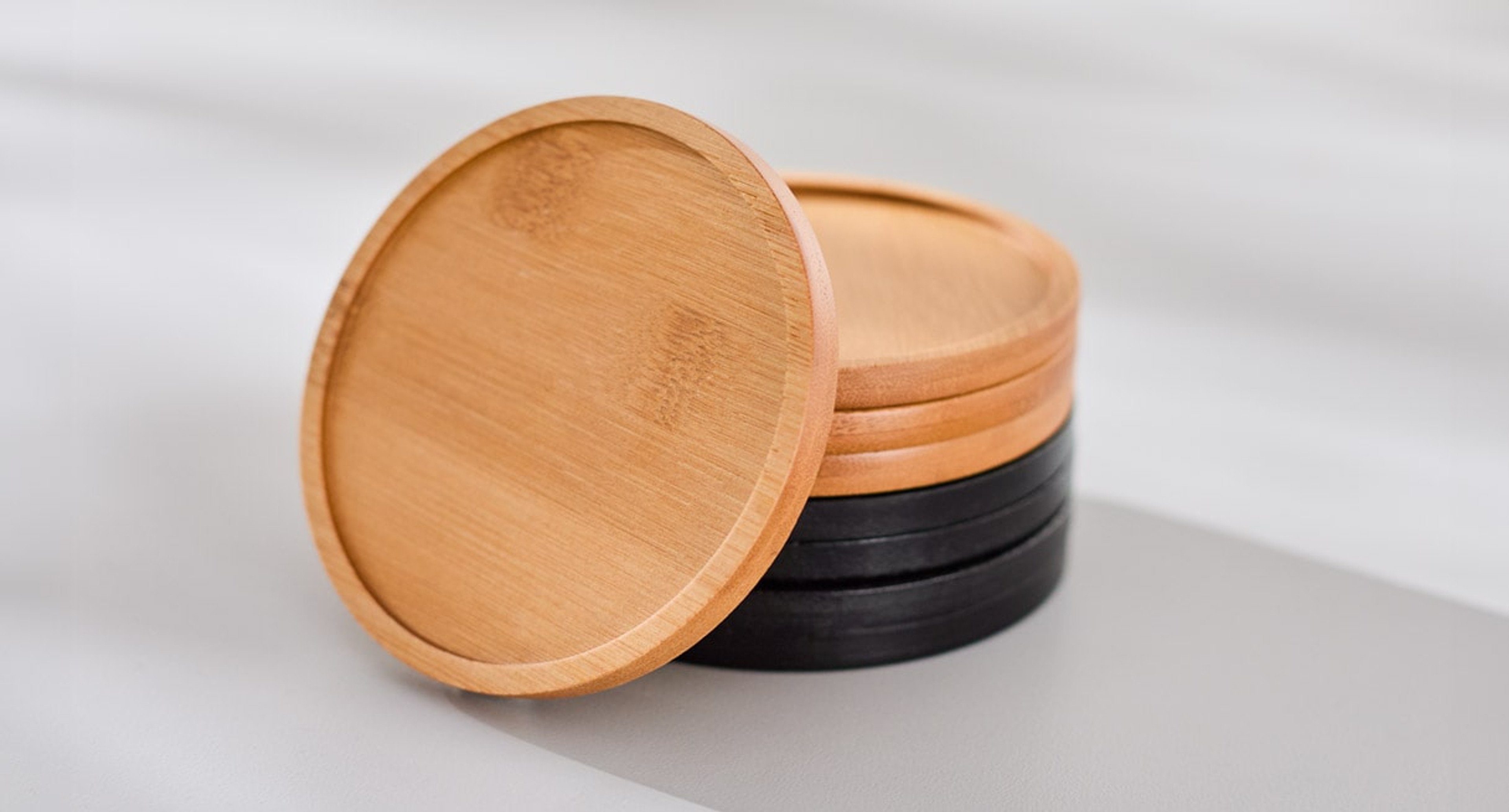 Bamboo Coasters are available in natural or stained black bamboo colors, and sold in sets of four matching colors