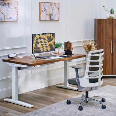 UPLIFT V3 Standing Desk with a Walnut Butcher Block desktop, a Vert Ergonomic Chair, and a MoPac Wardrobe in Walnut Laminate