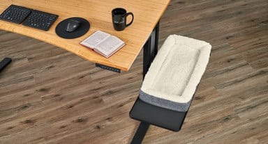 A Desk Pet Bed on a Sidecar Shelf mounted to a 60" x 30" Bamboo Curve UPLIFT Standing Desk
