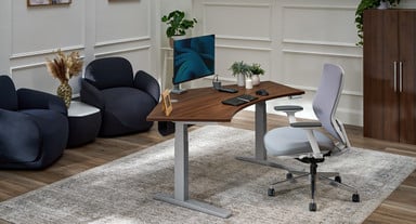 Home office setting featuring UPLIFT Desk furniture. Focal point is a 120-Degree Standing Desk with accessories and seating