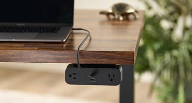 Attach the power strip below the desktop with the included under mount bracket and screws