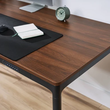 The 60" x 30" English walnut laminate desktop included with the QuadZen Standing Desk
