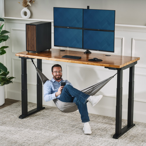 The Under Desk Hammock attached to the frame mounting system of an UPLIFT 4-Leg Standing Desk